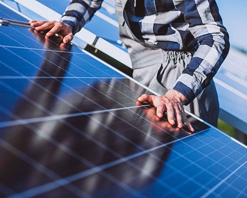 Man worker in the firld by the solar panels